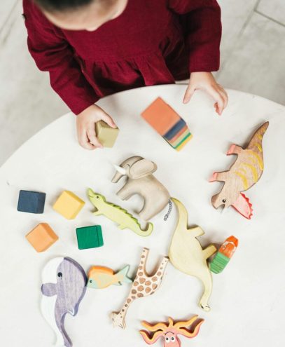 A kid playing with animal toys